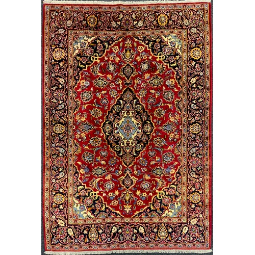 2057 - A Central Persian Kashan rug, in tones of red, pale blue, deep indigo, and cream, 210cm x 145cm.