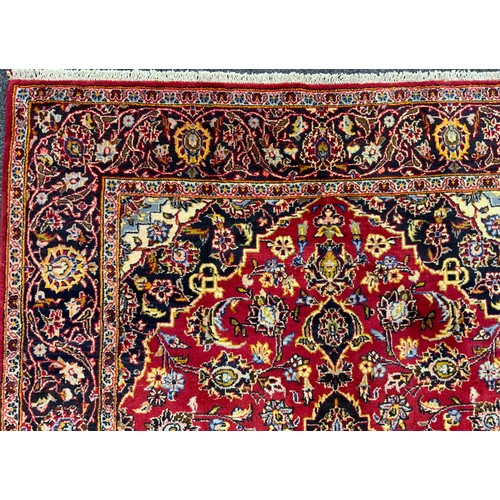 2057 - A Central Persian Kashan rug, in tones of red, pale blue, deep indigo, and cream, 210cm x 145cm.