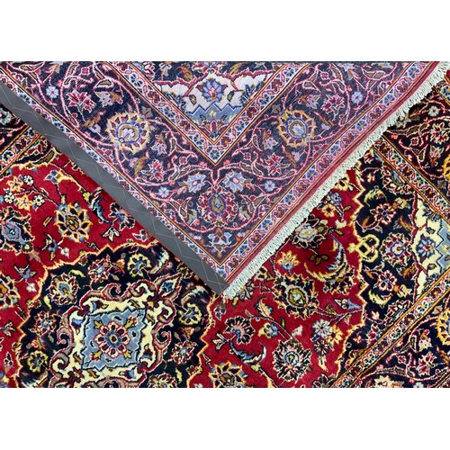 2057 - A Central Persian Kashan rug, in tones of red, pale blue, deep indigo, and cream, 210cm x 145cm.