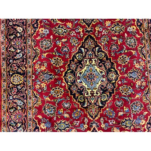 2057 - A Central Persian Kashan rug, in tones of red, pale blue, deep indigo, and cream, 210cm x 145cm.