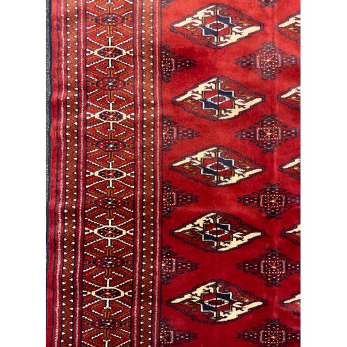 2073 - A Turkman rug, typical repeating Göl pattern, in rich tones of red, with white and black accents, 17... 