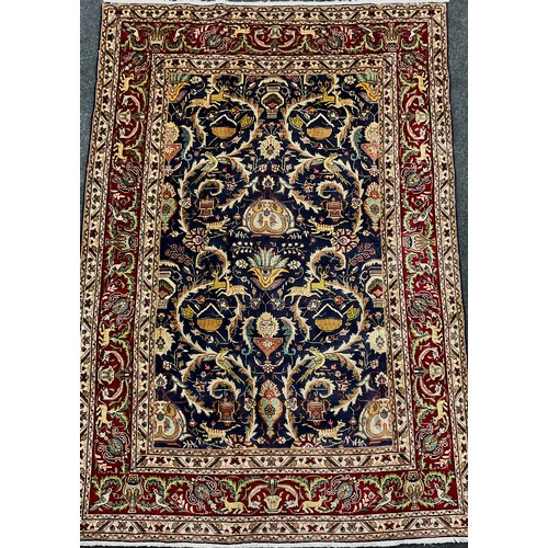 2071 - A Tabriz rug, knotted with a stylised field of scrolling leafy stems, flowers, and animals, in rich ... 