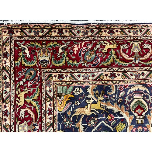 2071 - A Tabriz rug, knotted with a stylised field of scrolling leafy stems, flowers, and animals, in rich ... 