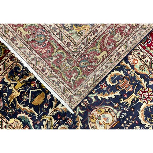 2071 - A Tabriz rug, knotted with a stylised field of scrolling leafy stems, flowers, and animals, in rich ... 