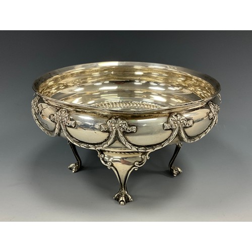 219 - A George V silver bowl, cast with tied ribbons, bows and swags, raised on four clawed feet, 16.7cm d... 