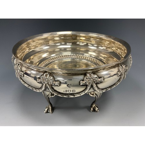 219 - A George V silver bowl, cast with tied ribbons, bows and swags, raised on four clawed feet, 16.7cm d... 