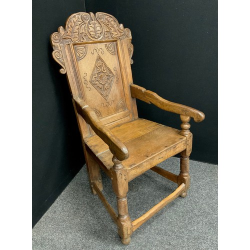 1528 - A 17th century oak Wainscot armchair, arched cresting rail carved with stiff leaves and the initials... 