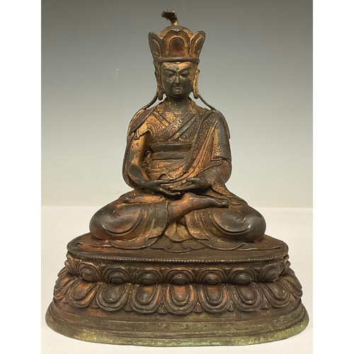 369 - A reproduction Chinese coppered metal figure, of a deity, seated in meditation, 24.5cm high, 20cm wi... 