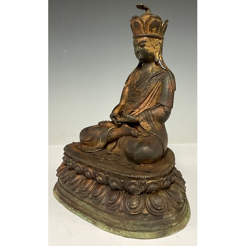 369 - A reproduction Chinese coppered metal figure, of a deity, seated in meditation, 24.5cm high, 20cm wi... 