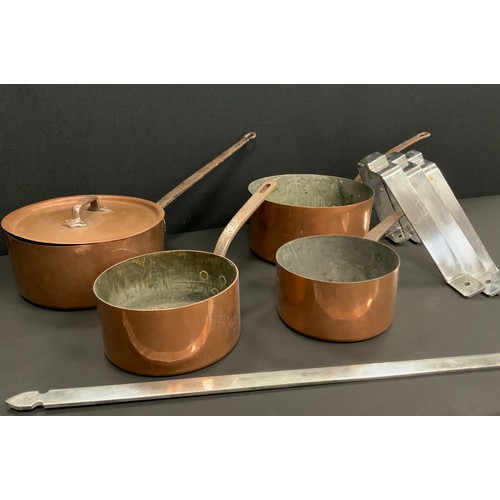 2150 - A graduated set of four 19th century copper and cast iron pans, with associated pan hanging rack.