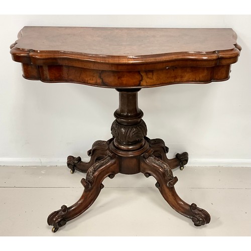 1789 - A Victorian walnut card table, serpentine top, carved and turned column, scrolling feet, 73cm x 92cm... 