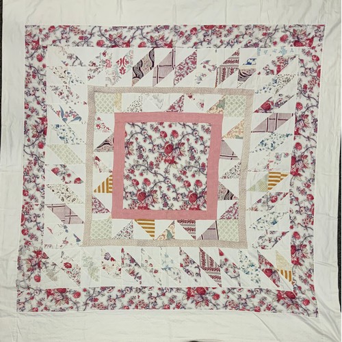 2100 - A late 19th/early 20th century patchwork quilt, with floral centre, surrounded by triangular and squ... 