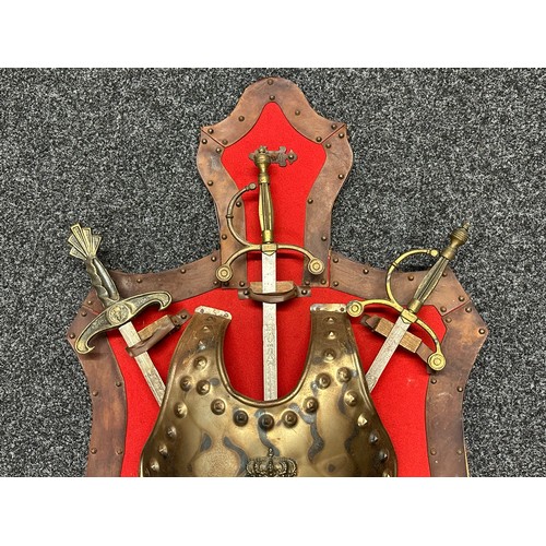 629 - A large wall mounted decorative display of a reproduction breast plate with three crossed swords. Si... 