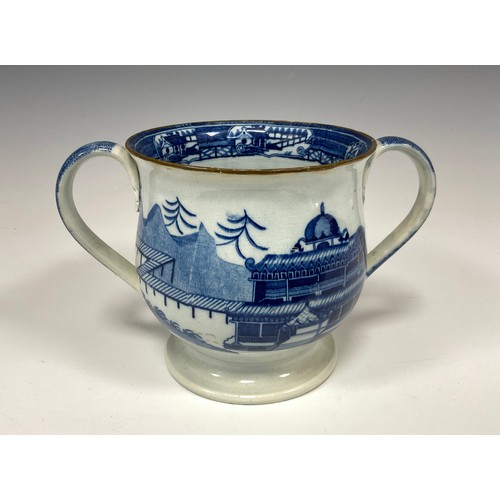 1189A - An early 19th century English pearlware loving cup, blue transfer printed with chinoiserie scene dep... 