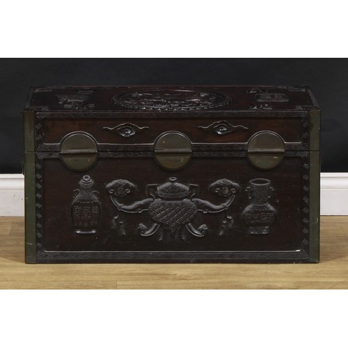 1535A - A Chinese hardwood rectangular chest, carved in relief with precious objects, characters and an elep... 