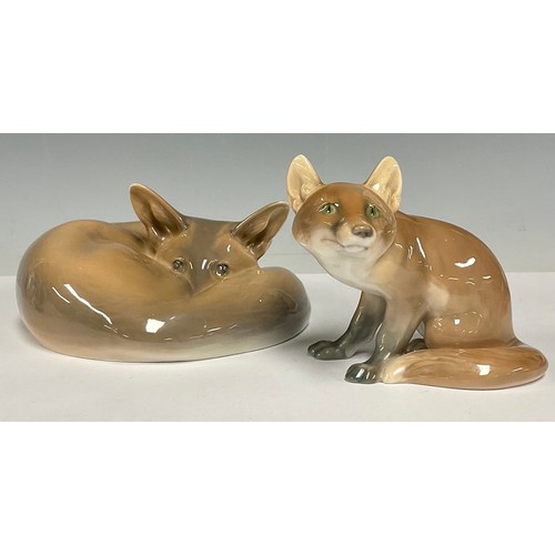 12 - A Royal Copenhagen porcelain model, of a curled up fox, shape no. 438, 17cm wide; a Bing & Grondahl ... 