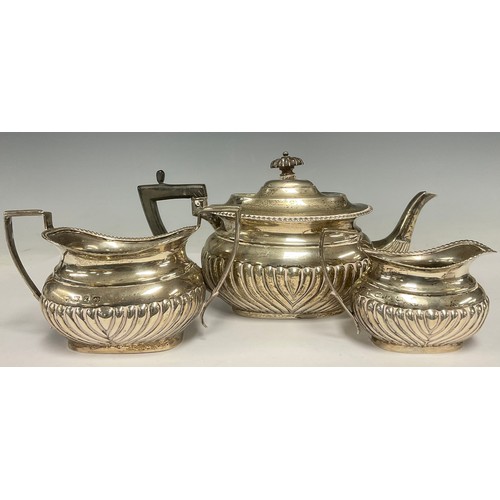 44 - A late Victorian silver composed half fluted three-piece tea service, the teapot, London 1898, the c... 