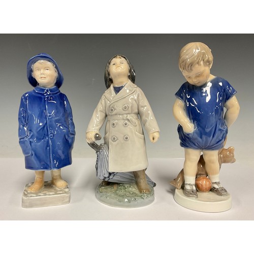 59 - A Royal Copenhagen porcelain figure, of a boy wearing a raincoat and hat, shape no. 3556, 18cm high;... 