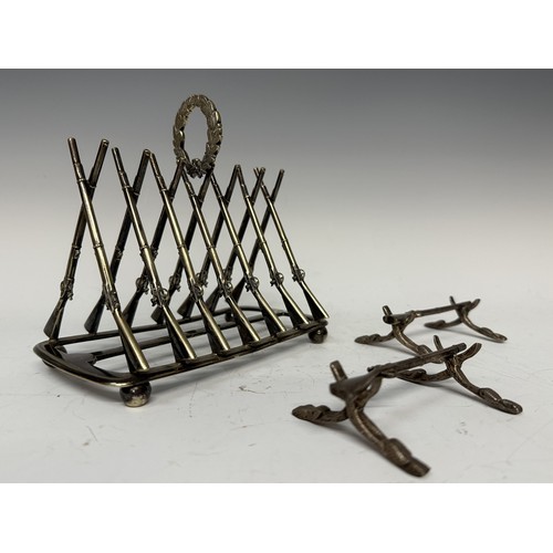 3145 - Silver Plated Toast Rack and pair of knife rests in the form of crossed Muskets. Length of toast rac... 