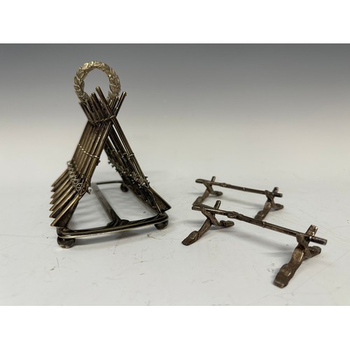 3145 - Silver Plated Toast Rack and pair of knife rests in the form of crossed Muskets. Length of toast rac... 