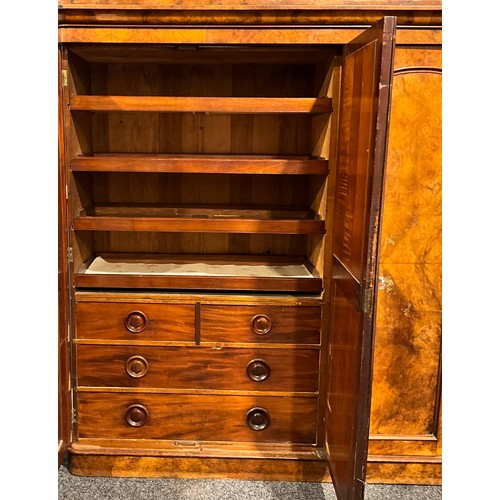 120 - A Victorian walnut wardrobe, moulded cornice above three doors, the central mirrored, enclosing line... 