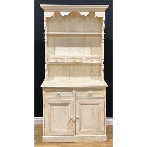 218 - A 19th century style painted pine dresser, of narrow proportions, moulded cornice above a pair of pl... 