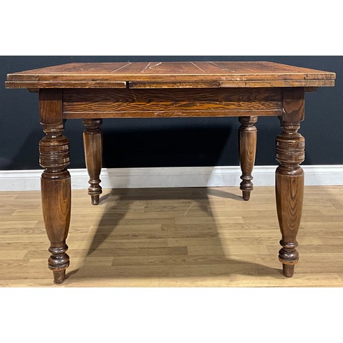 402 - An early 20th century oak draw-leaf dining table