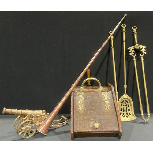 335 - An Arts & Crafts oak fuel bin, brass fittings, 43cm long; a large brass fireside cannon, 43cm long; ... 