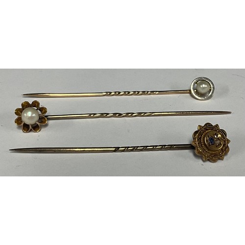 493 - A 15ct gold rose cut diamond and pale blue sapphire tie pin, 1.8g gross;  two others seed pearl and ... 