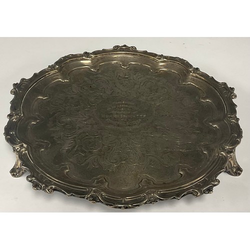 43 - An Elizabeth II silver shaped circular salver, scroll border, three scroll feet, the field with pres... 