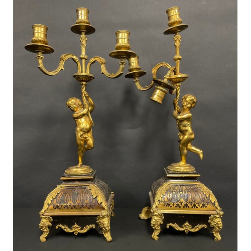 74 - A pair of Louis XV style gilt metal and Boulle three-light figural candelabra, the supports cast as ... 