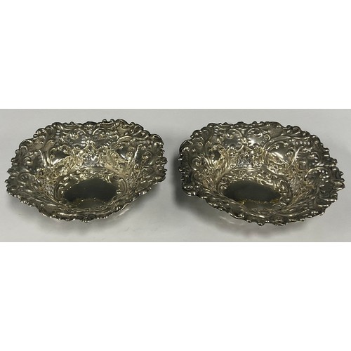 22 - An Edwardian silver shaped circular sweetmeat dish, pierced and chased with scrolls, 13cm diameter, ... 