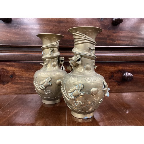 103 - A pair of Chinese brass vases, cast with trailling dragons amongst clouds, cast marks, 24cm high (2)