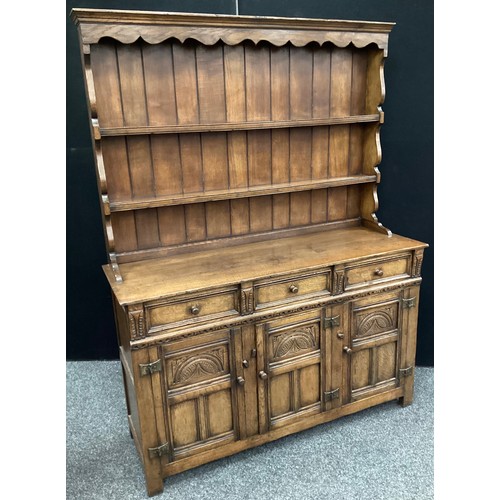 113 - A Titchmarsh and Goodwin oak dresser, plate-rack top, three short drawers to frieze, above three car... 