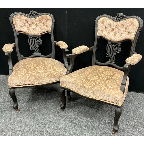 139 - A pair of Victorian ‘Rococo’ style carved armchairs, upholstered button-backs, upholstered arms, and... 