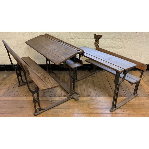 22 - A 19th century cast iron and pitch pine school bench desk, the sloping writing surface hinged to lif... 