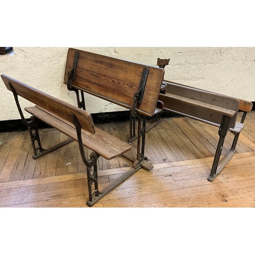 22 - A 19th century cast iron and pitch pine school bench desk, the sloping writing surface hinged to lif... 