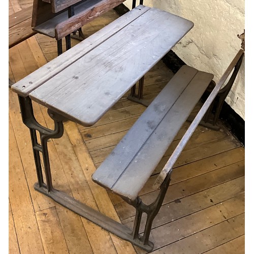 22 - A 19th century cast iron and pitch pine school bench desk, the sloping writing surface hinged to lif... 