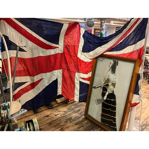 53 - A Union Jack flag, 155cm x 340cm;  and a framed display of a lady wearing samples of fabric produced... 