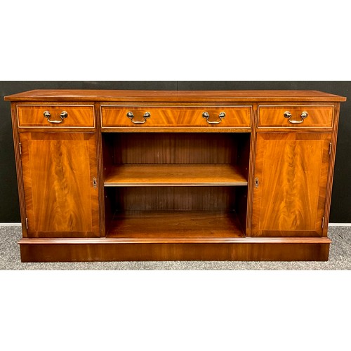 418 - A mahogany bookcase cabinet, over-sailing top with three drawers to frieze, above a central shelving... 