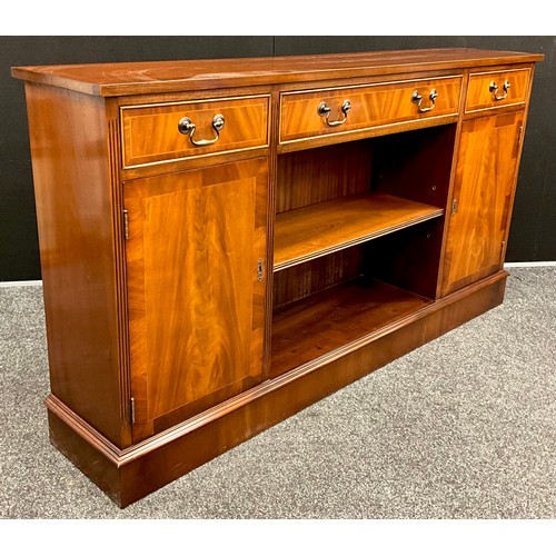 418 - A mahogany bookcase cabinet, over-sailing top with three drawers to frieze, above a central shelving... 