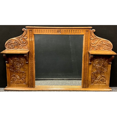 449 - An early 20th century carved oak over-mantle mirror, the side panels and cresting carved in relief w... 