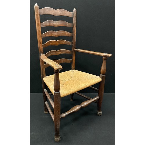 588 - An early 19th century oak and elm ladder-back armchair, 115cm high x 65cm wide x 53cm deep.