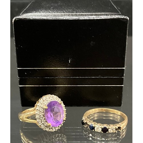 903 - A diamond and amethyst oval cluster ring, central oval pale purple amethyst surrounded by a double l... 