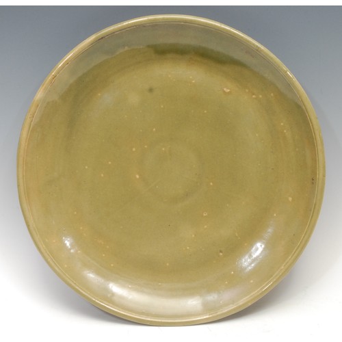 1297 - A Chinese celadon charger, broad base, shallow sides, moulded everted rim, three radial lines, of pl... 