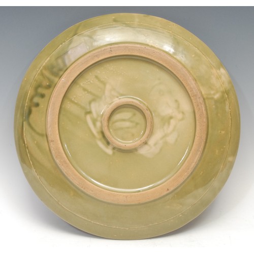 1297 - A Chinese celadon charger, broad base, shallow sides, moulded everted rim, three radial lines, of pl... 