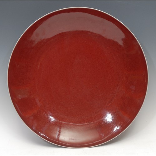 1309 - A large Chinese sang-de-boeuf charger, broad base, shallow sides, deep red ox-blood glaze with fine ... 