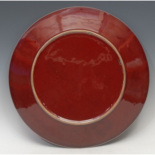 1309 - A large Chinese sang-de-boeuf charger, broad base, shallow sides, deep red ox-blood glaze with fine ... 