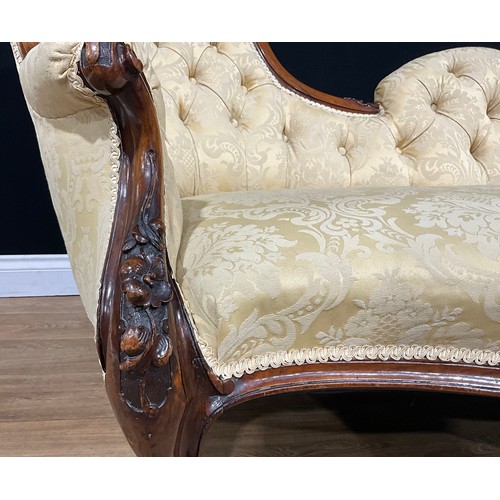 2464 - A Victorian walnut chaise longue, stuffed-over upholstery, the frame carved with bell husks and flow... 