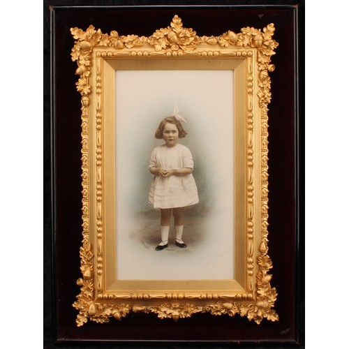 2566 - Photography - an early 20th century presentation studio portrait photograph, of a young girl, colour... 